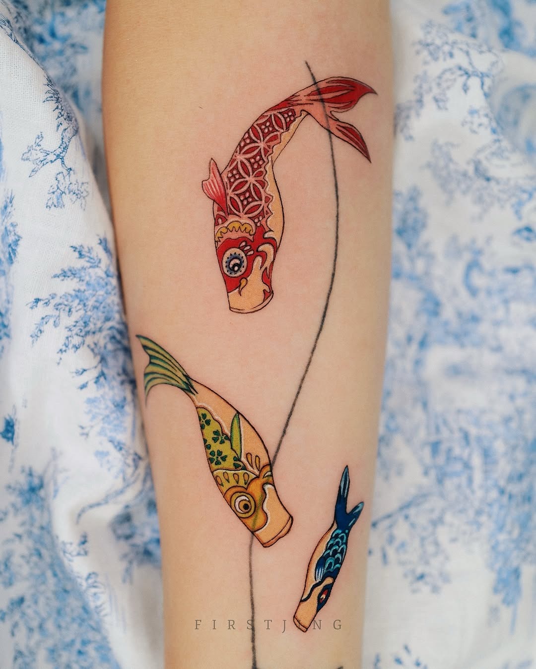 This arm tattoo showcases three beautifully designed koi fish in colors.