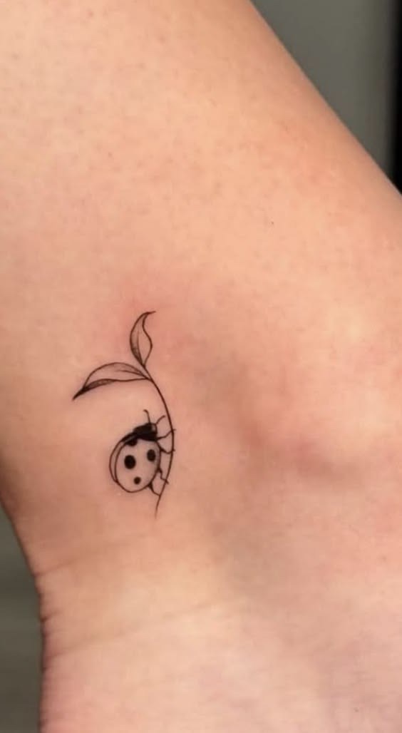 Minimalist Ladybug Hanging From a Leaf Tattoo Design