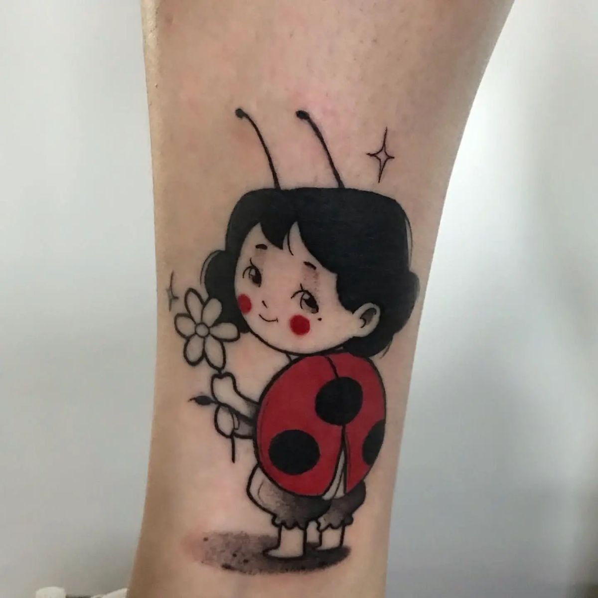 Whimsical Ladybug Girl Tattoo With a Flower Tattoo Design