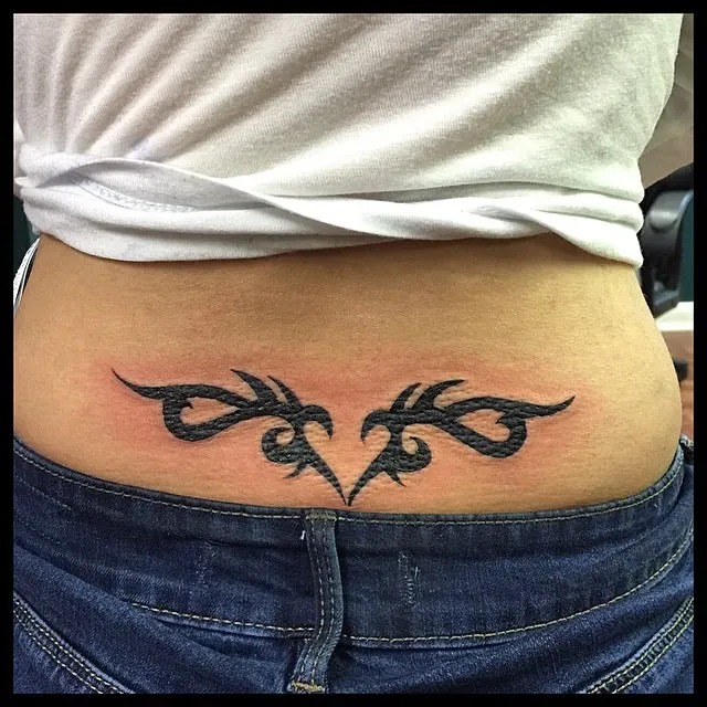 This bold tribal tattoo showcases symmetrical lines and sharp edges, embodying strength and tradition.