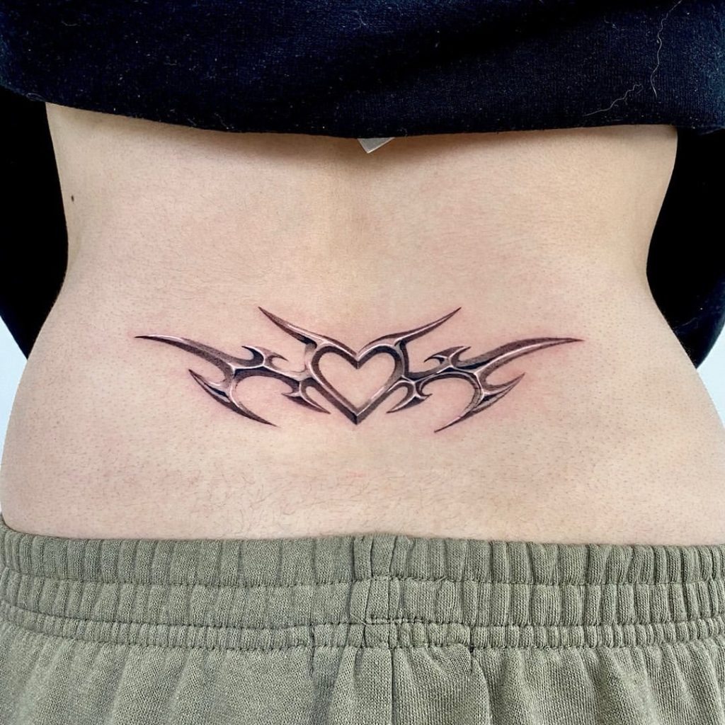 This striking tattoo blends tribal patterns with a bold heart motif at its center.