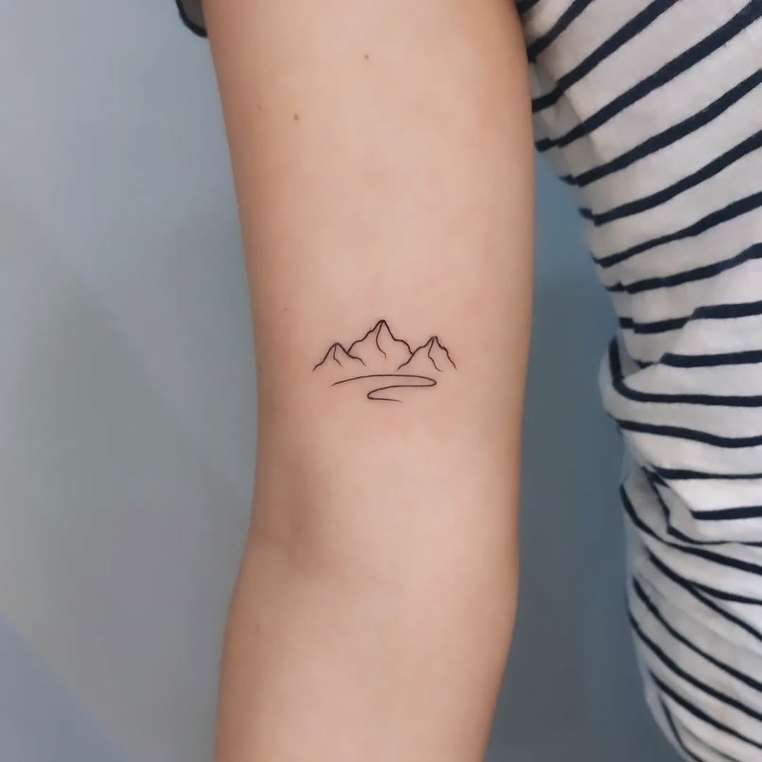 Minimalistic mountain outline tattoo on arm Tattoo Design