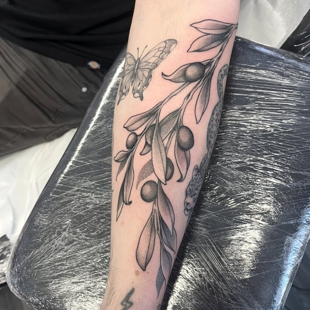 Elegant olive branch tattoo with butterfly detail Tattoo Design