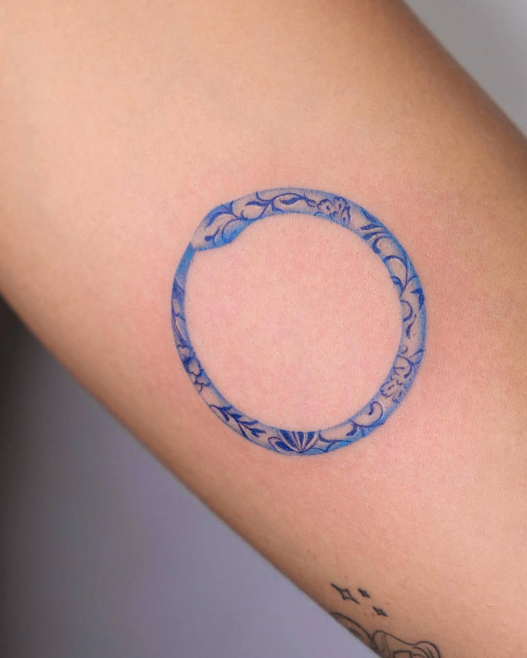 Elegant blue ouroboros tattoo with floral motifs Tattoo Design