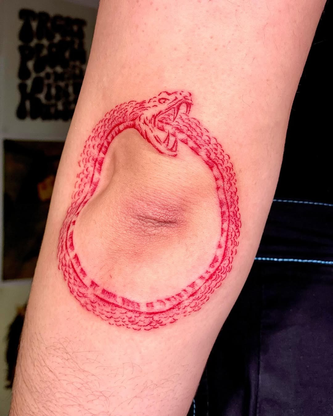 Intricate red ouroboros tattoo on the arm Tattoo Design