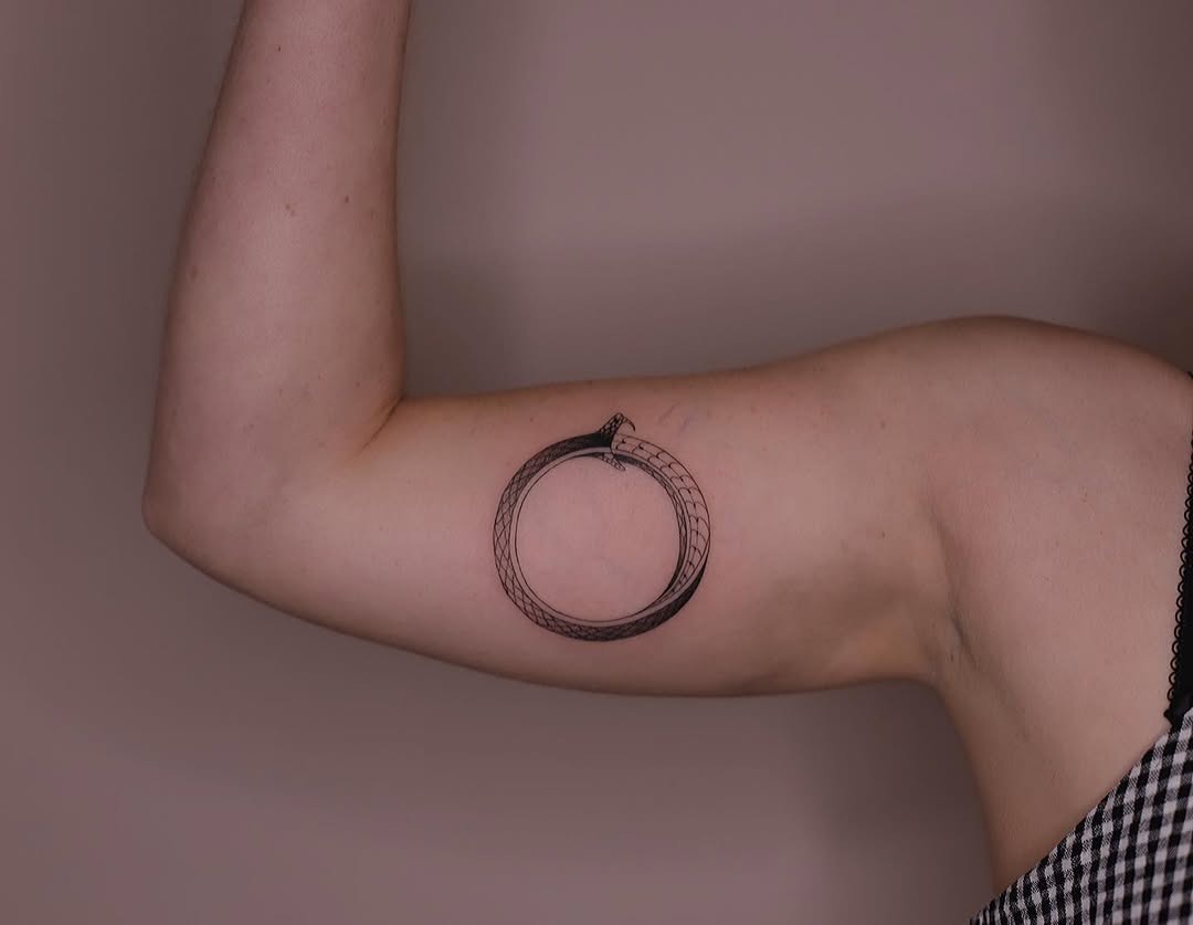 Striking minimalist ouroboros tattoo on arm Tattoo Design