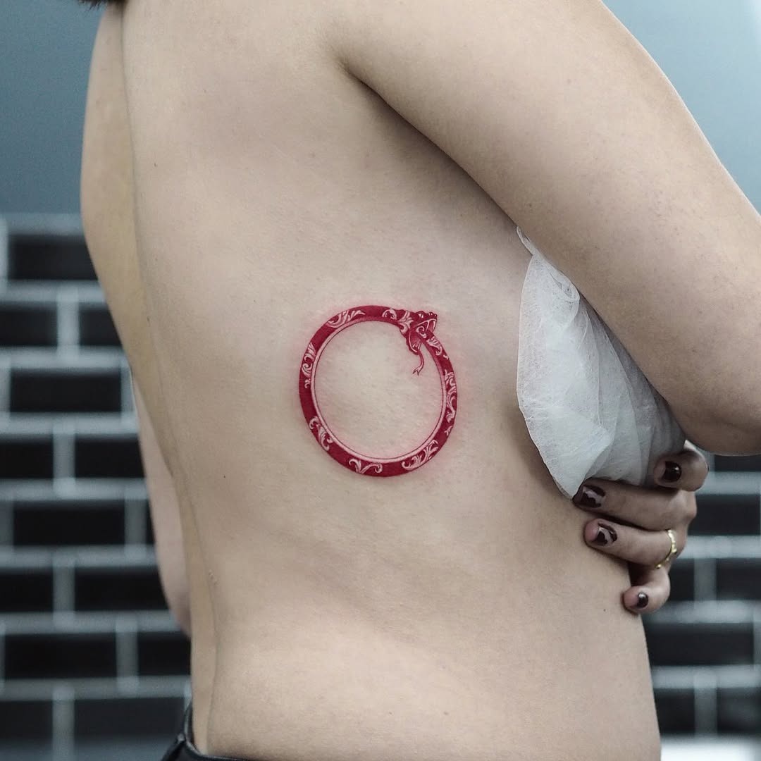 Striking red ouroboros tattoo on skin Tattoo Design