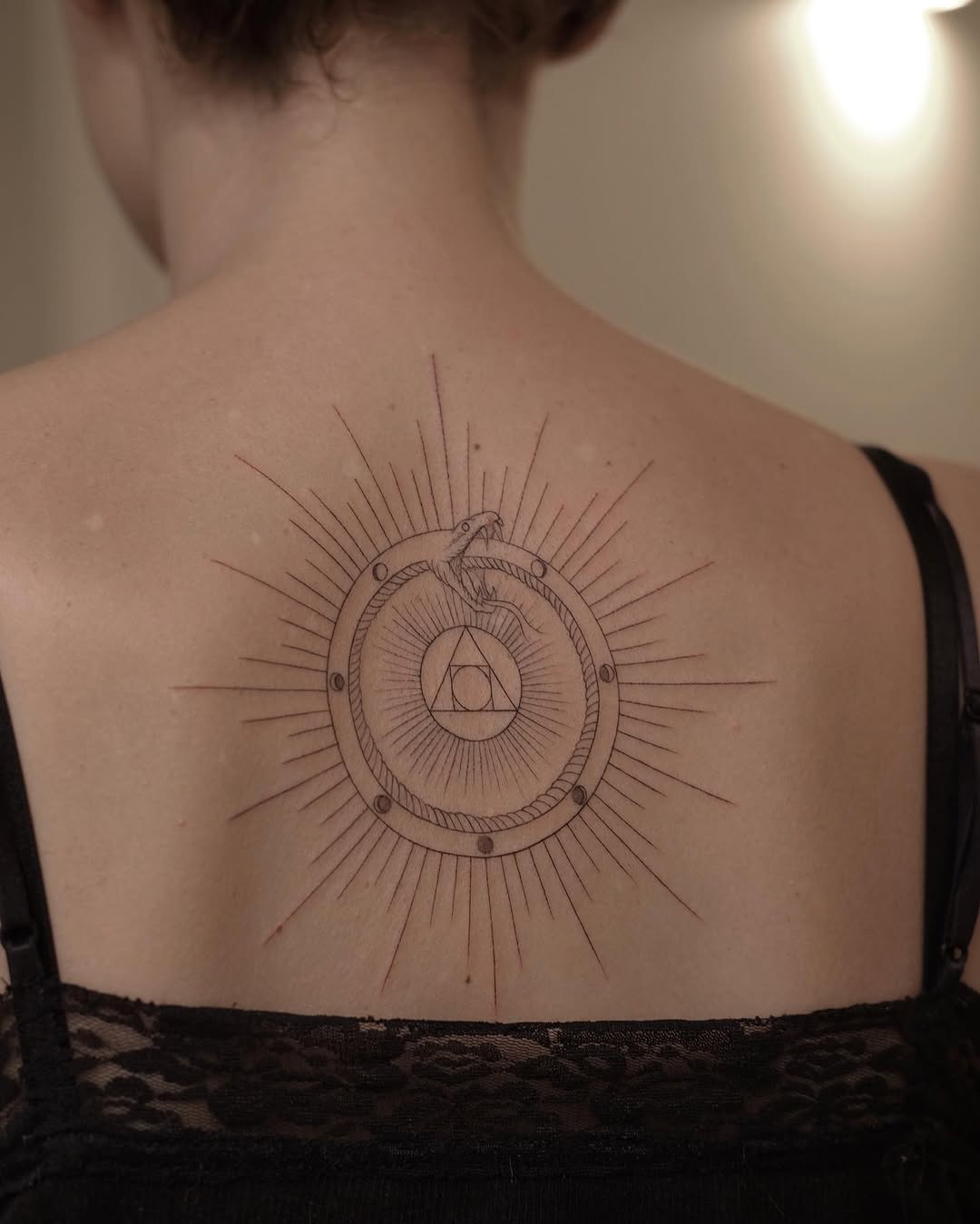 Stunning Ouroboros Design with Radiant Sun Rays Tattoo Design