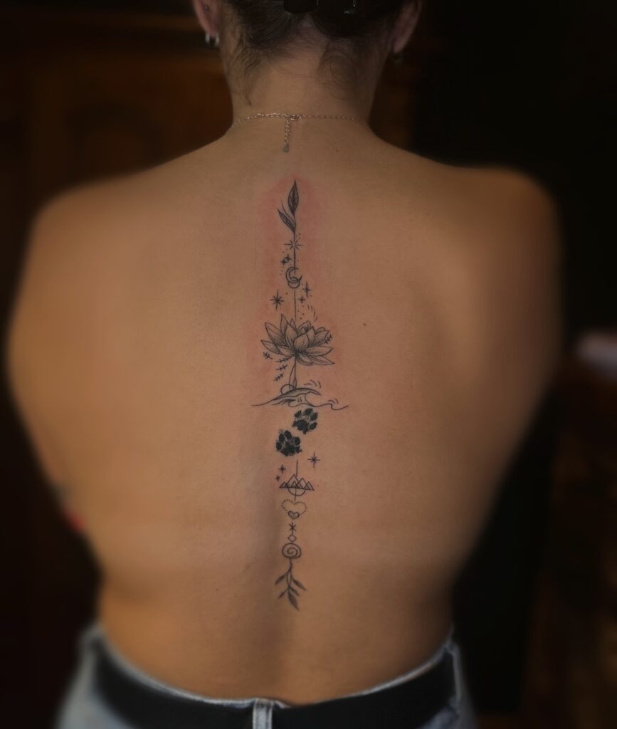 Elegant Lotus and Paw Print Spine Tattoo Tattoo Design