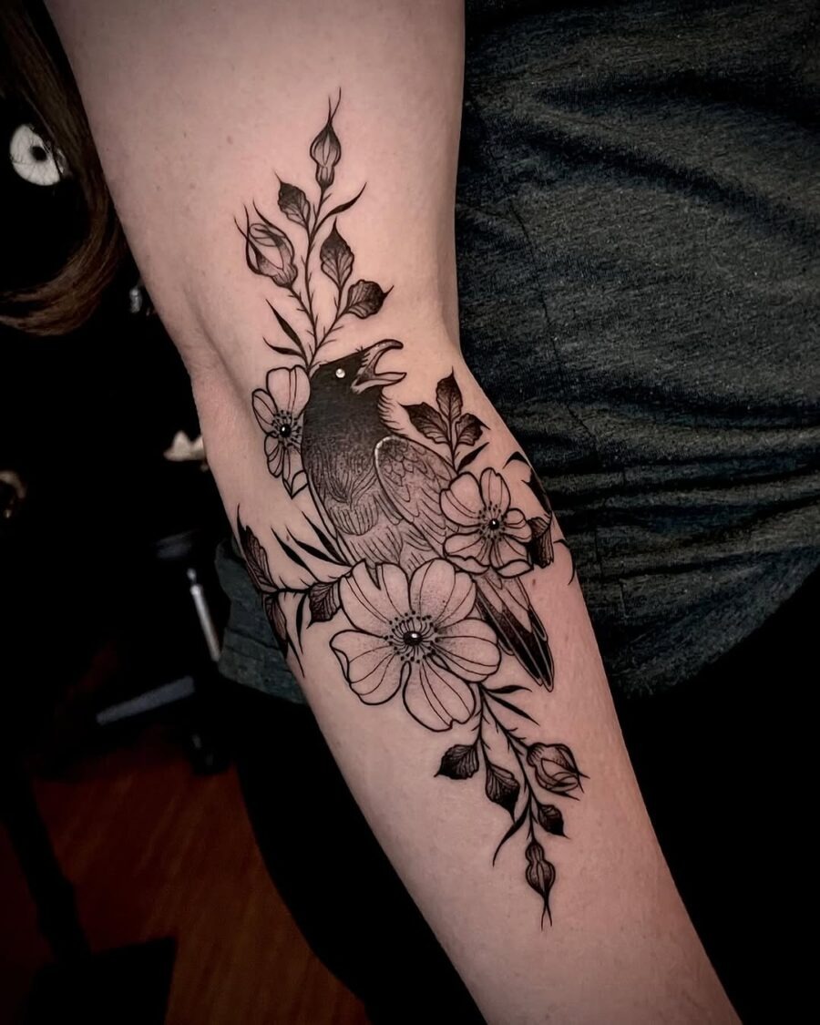 Elegant black ink raven tattoo with flowers Tattoo Design