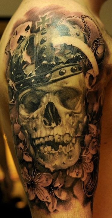 Dark skull tattoo on a guy’s upper arm Tattoo Design
