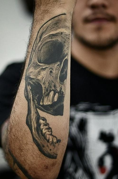 Intriguing skull tattoo on a man’s lower arm Tattoo Design