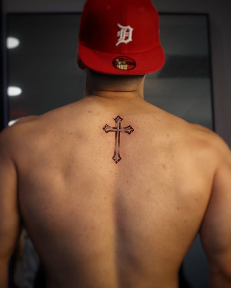 Simple yet deeply personal, this cross tattoo rests just below the neck.