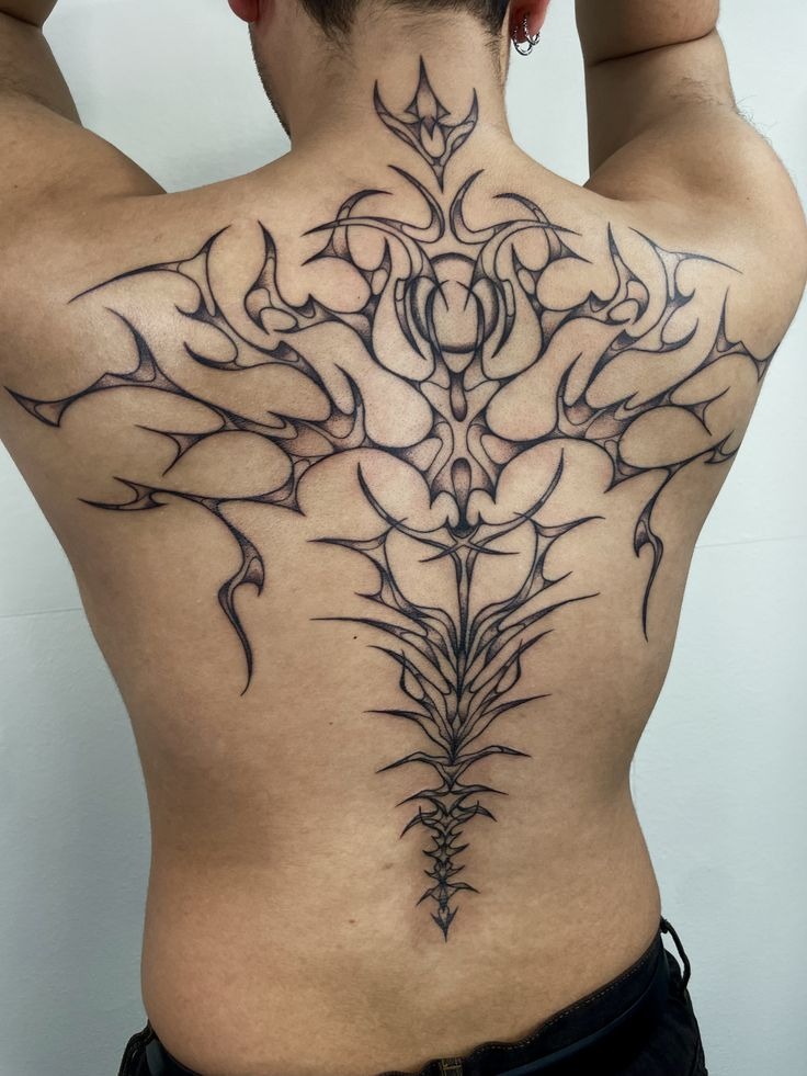 This tattoo stretches across the back like an organic web, drawing from tribal influences while using a modern, fine line technique.
