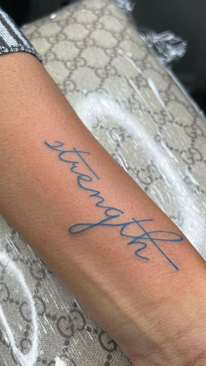 Elegant Strength Script With Cross Line, a tattoo design rendered in delicate fine-line for the forearm.