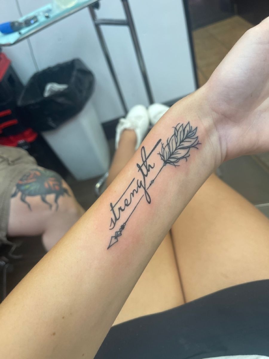 “Strength” Arrow Tattoo With Feather Detail, a tattoo design rendered in clean detailed linework for the back.