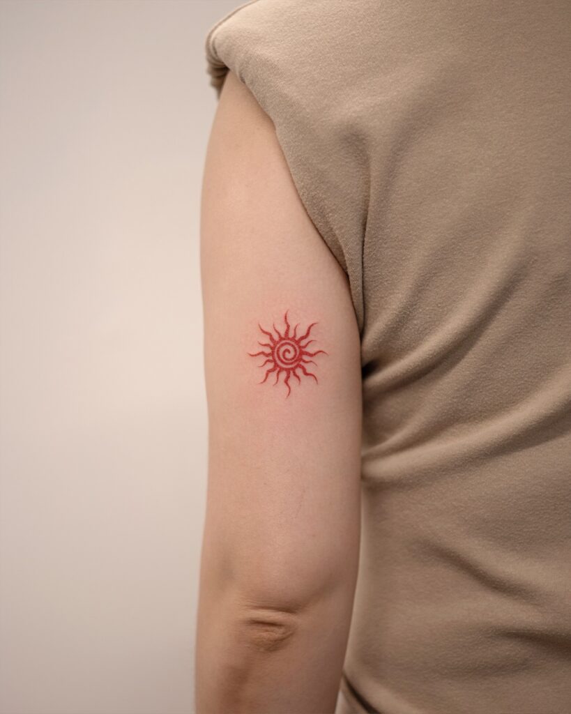 Red Spiral Sun Tattoo on Upper Arm Tattoo Design