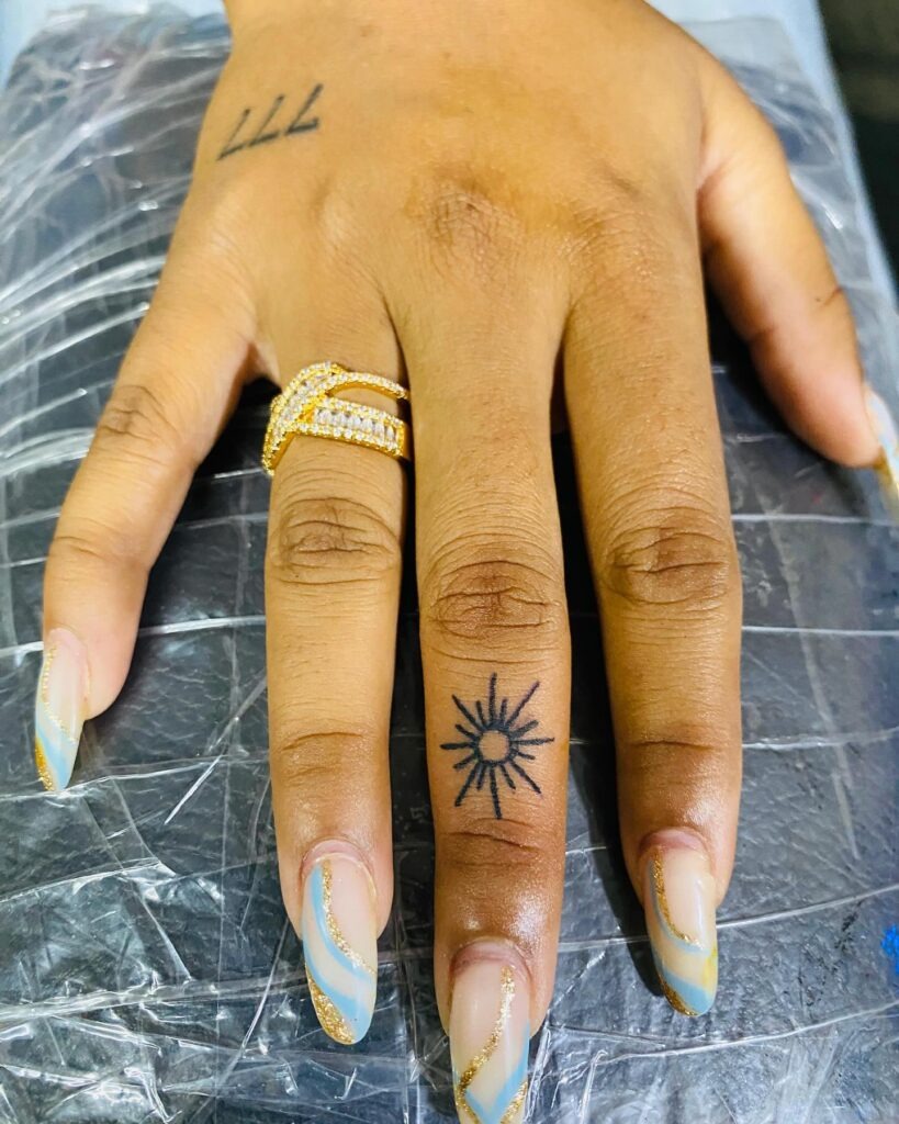 Tiny Sun Tattoo on Finger Tattoo Design