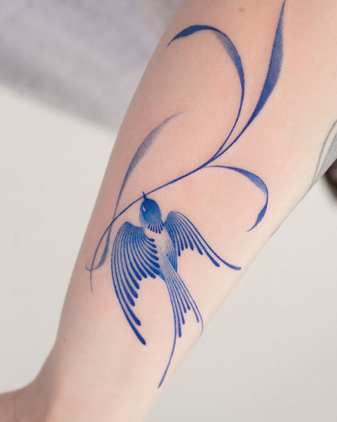 Elegant blue swallow tattoo with flowing lines Tattoo Design