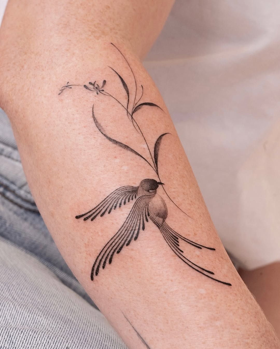 Elegant swallow tattoo with floral element Tattoo Design