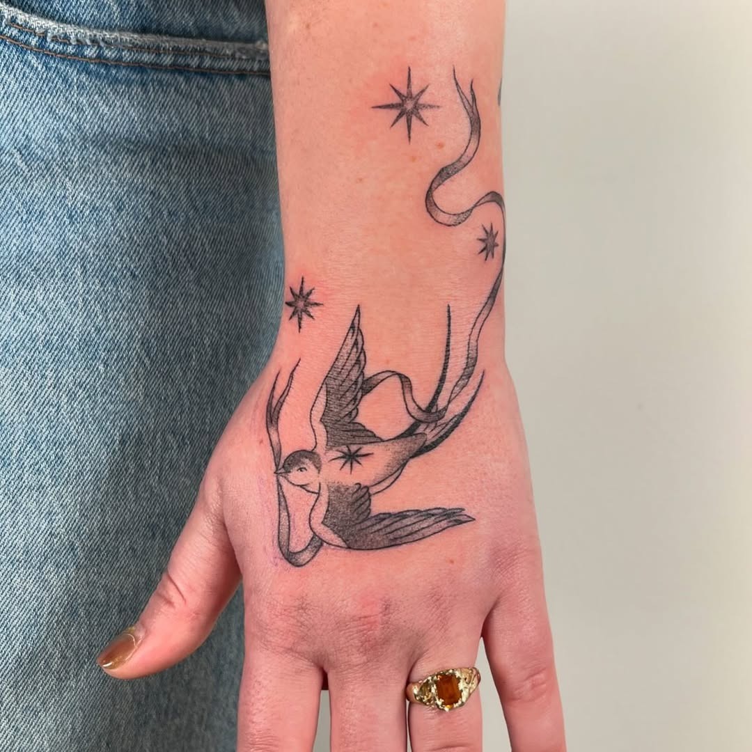 Elegant swallow tattoo with whimsical stars Tattoo Design