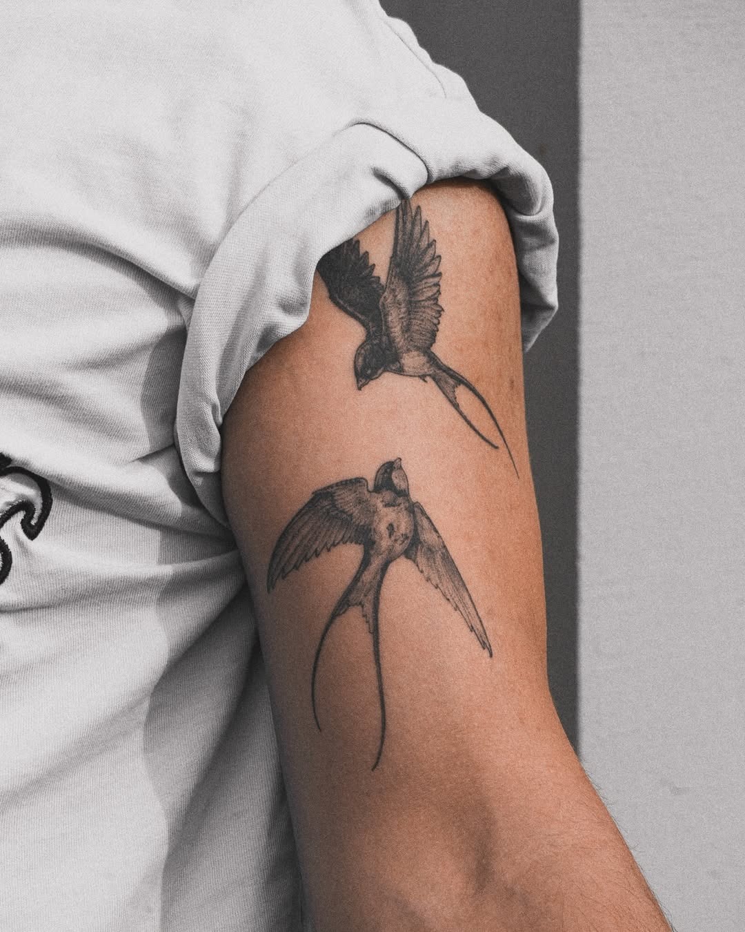 Elegant swallow tattoos take flight on arm. Tattoo Design