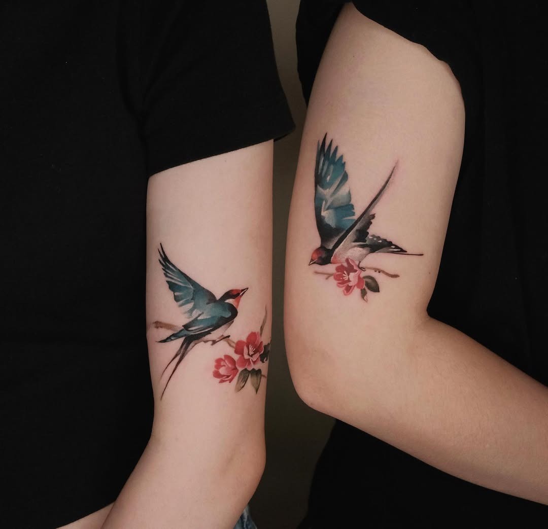 Elegant swallow tattoos with floral accents Tattoo Design