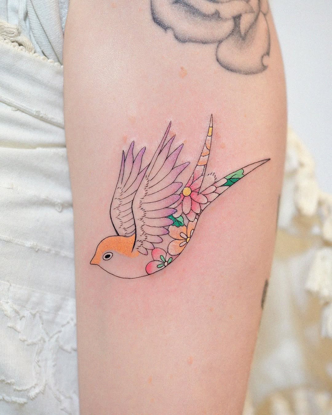 Vibrant swallow tattoo with floral elements Tattoo Design