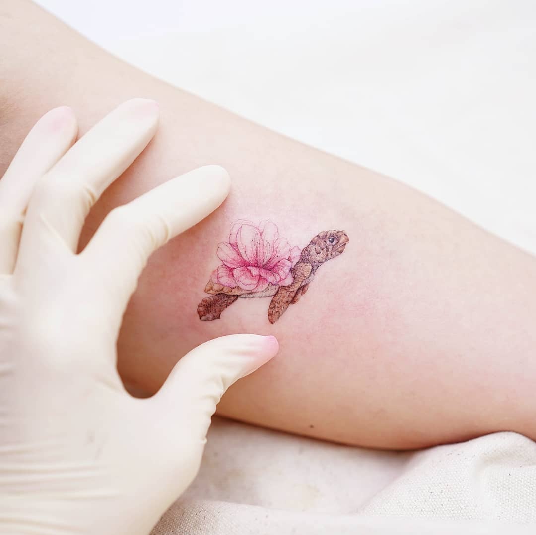 Delicate turtle tattoo with flower detailing Tattoo Design