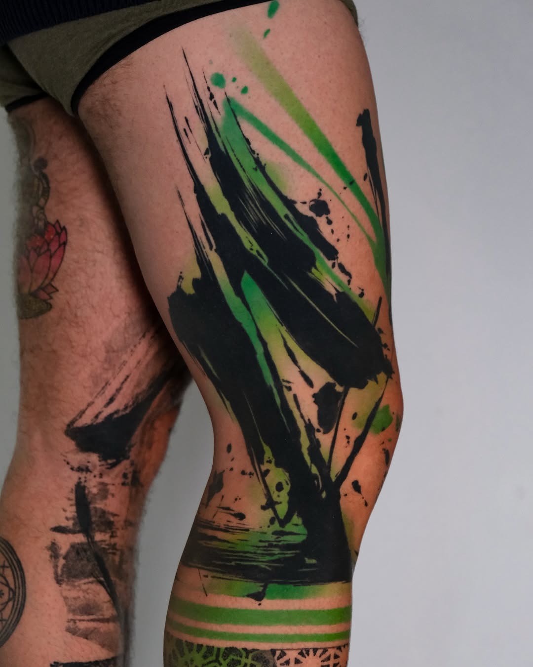 Dynamic splash of green and black ink Tattoo Design