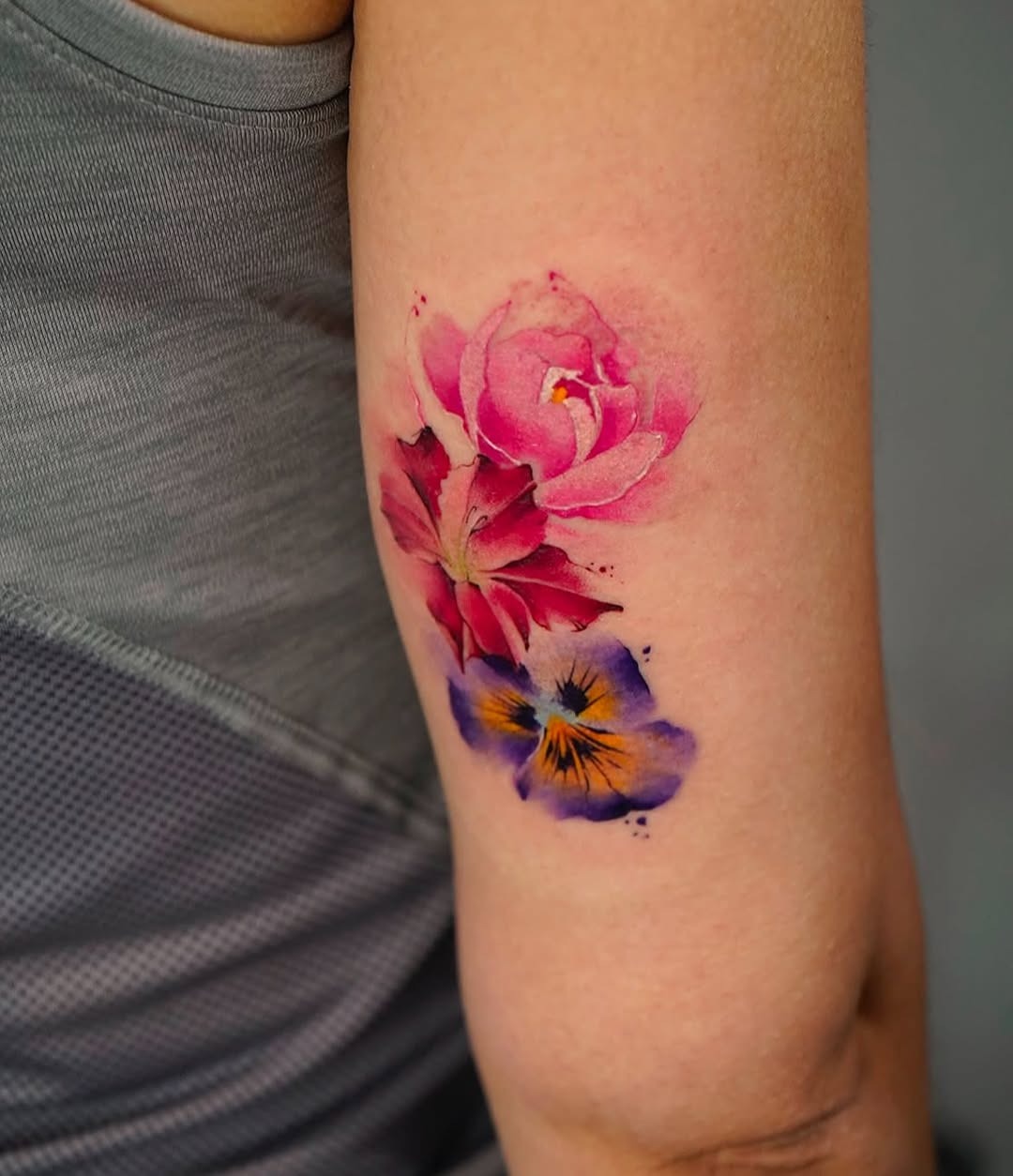 Vibrant floral watercolor tattoo on arm Tattoo Design
