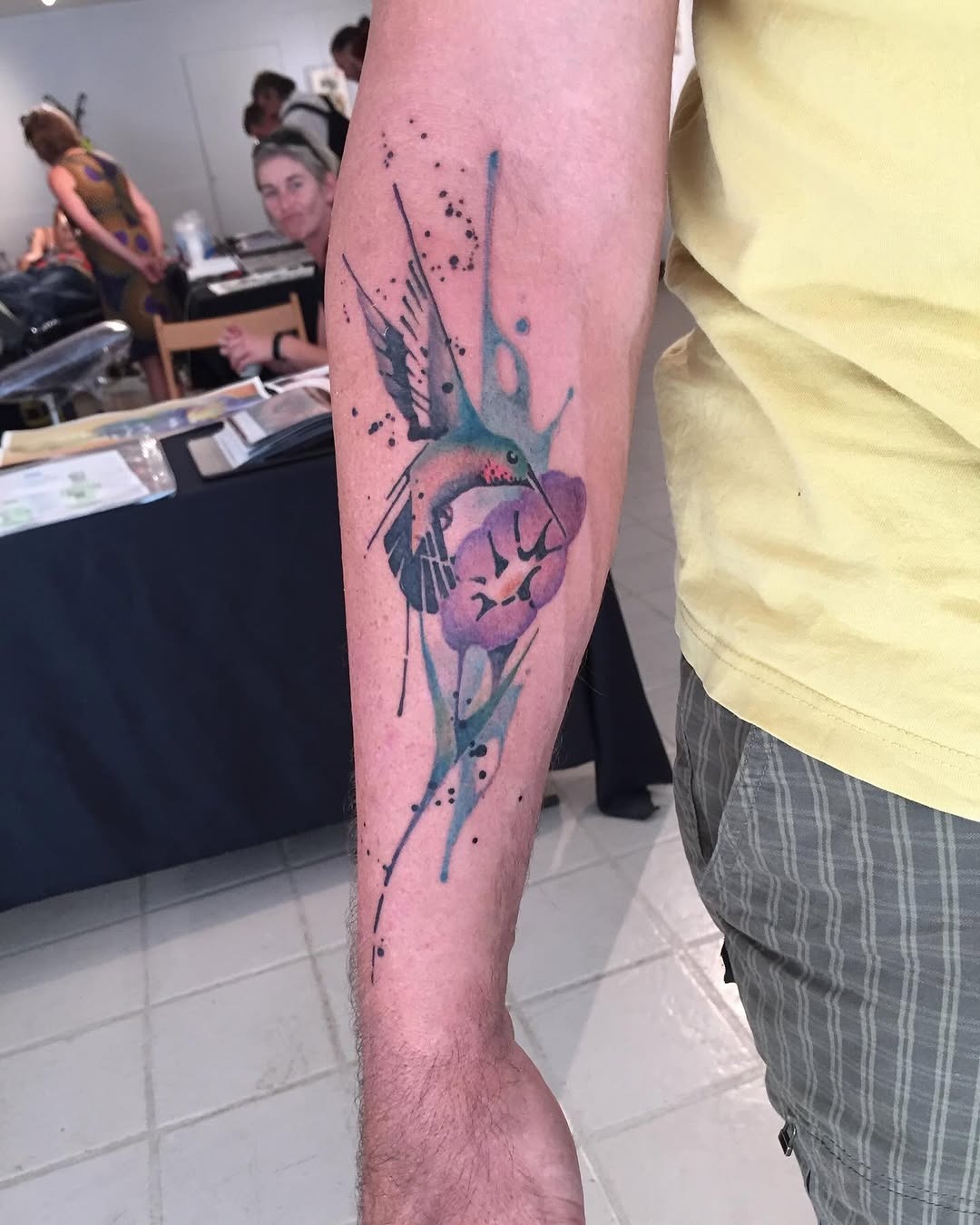 Vibrant hummingbird amidst floral watercolor hues Tattoo Design