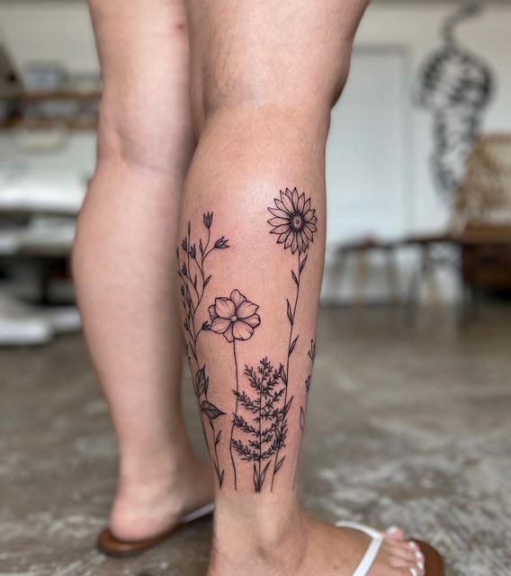 Black Ink Wildflower Outline on the Calf, a tattoo design rendered in sketch-style for the hand.