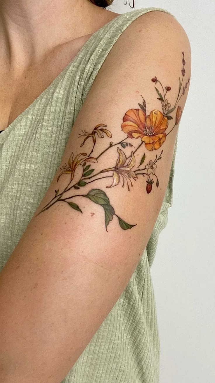 Soft Amber Blooms, a tattoo design rendered in delicate fine-line for the upper arm.