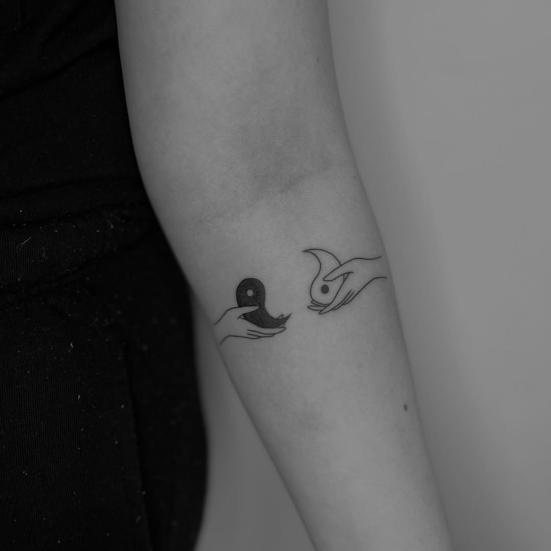 Creative hands holding yin yang symbols Tattoo Design