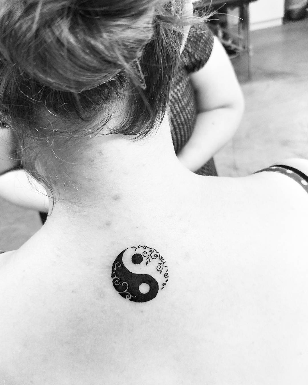 Elegant yin yang tattoo with floral accents Tattoo Design