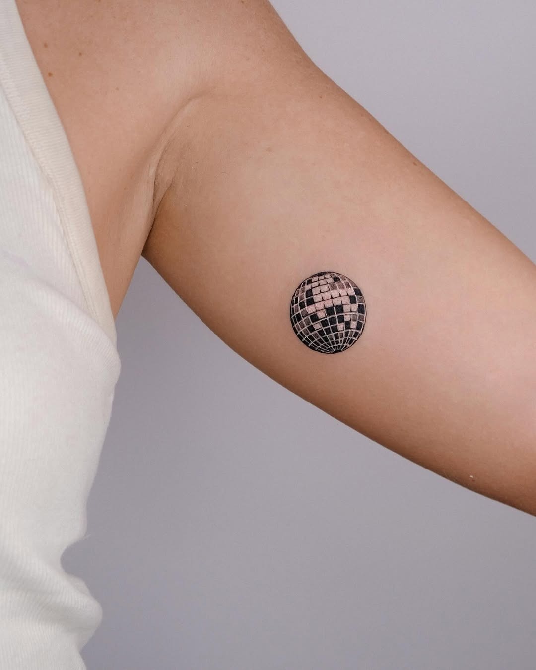 Minimalist disco ball tattoo on upper arm Tattoo Design