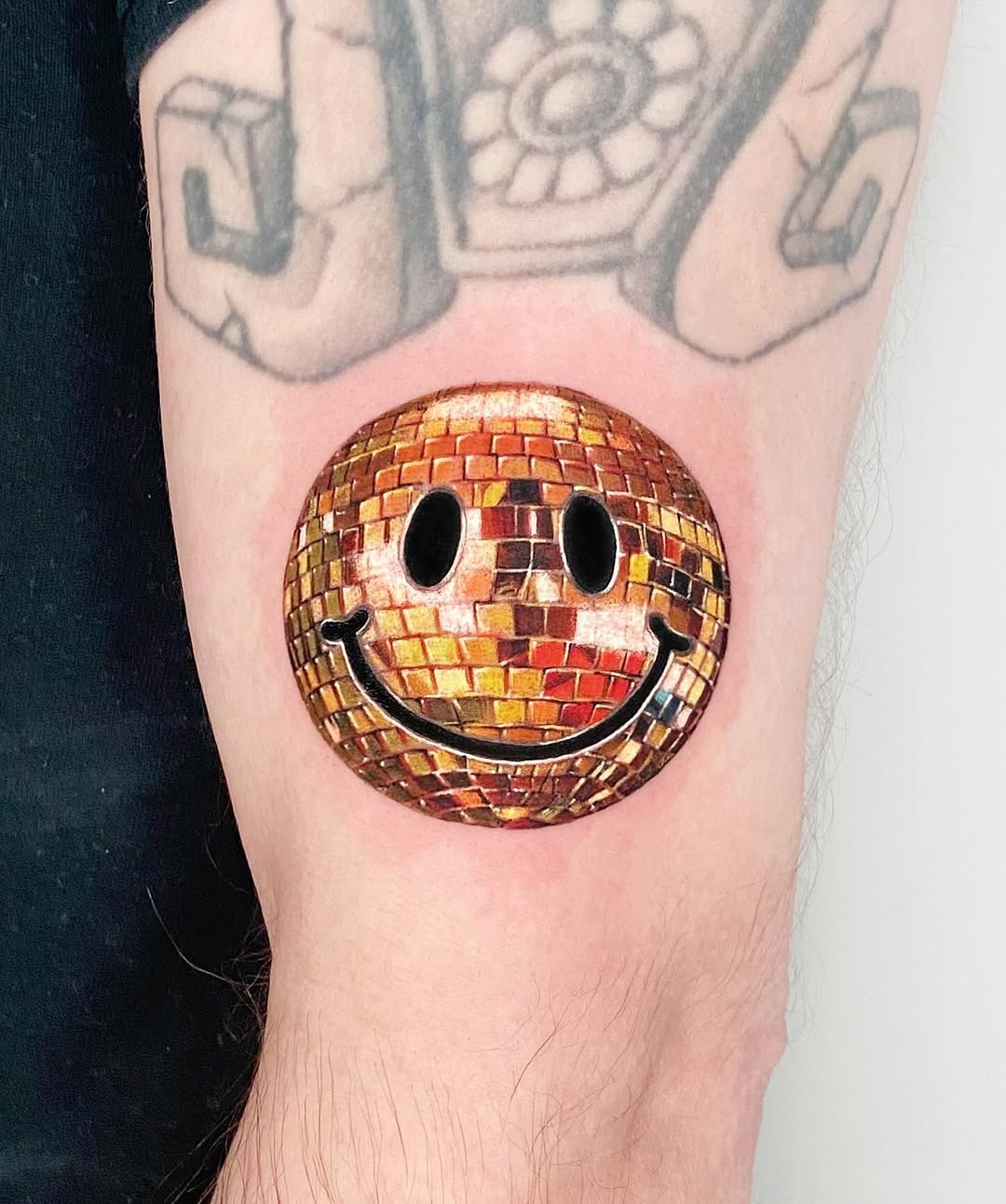 Vivid smiley disco ball tattoo on arm Tattoo Design