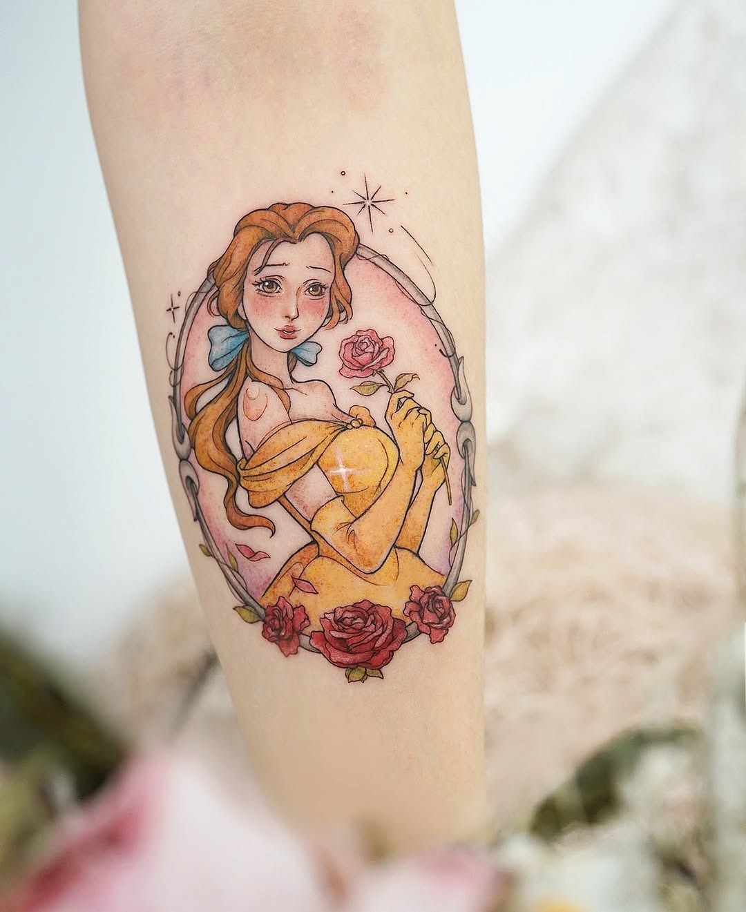 This tattoo features Belle holding a rose in a beautifully detailed portrait.
