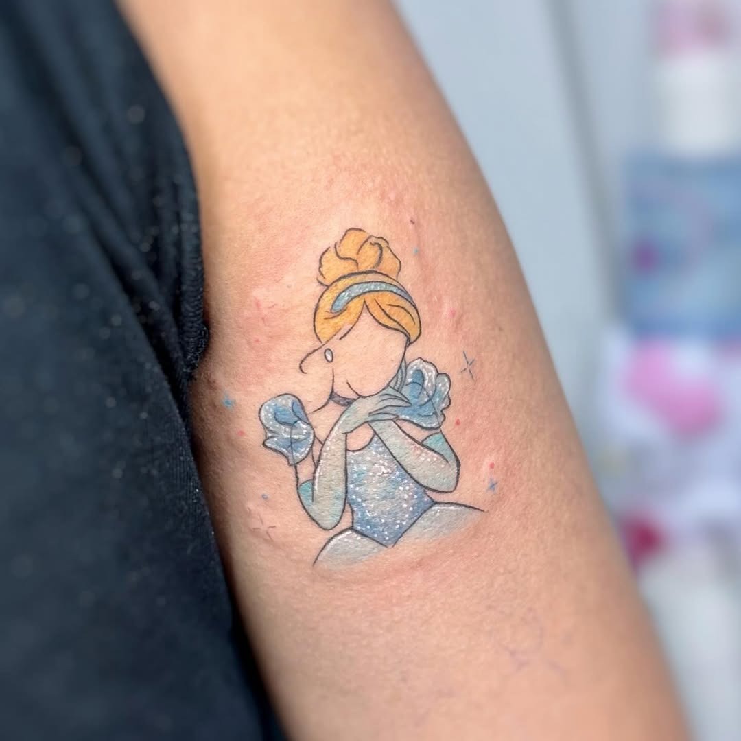 This whimsical Cinderella tattoo showcases her iconic gown and a graceful pose.