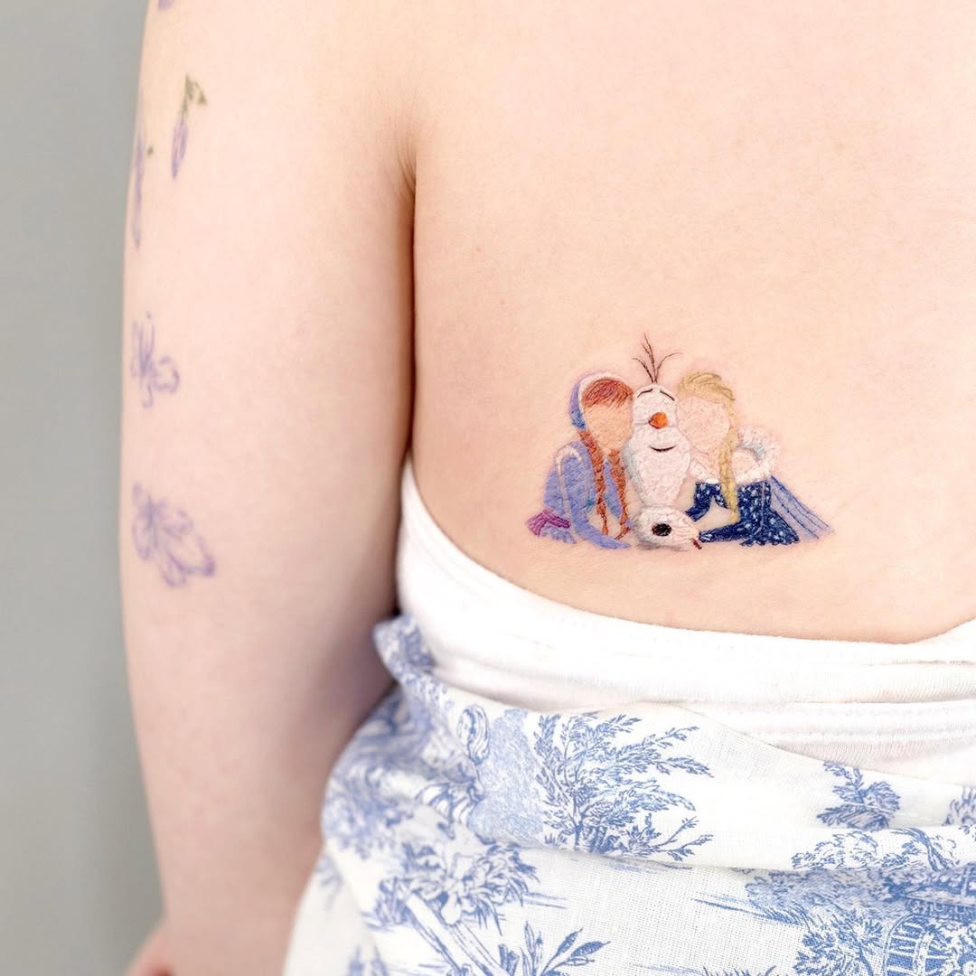 This delightful tattoo features Elsa, Anna, and Olaf nestled together in a warm embrace.