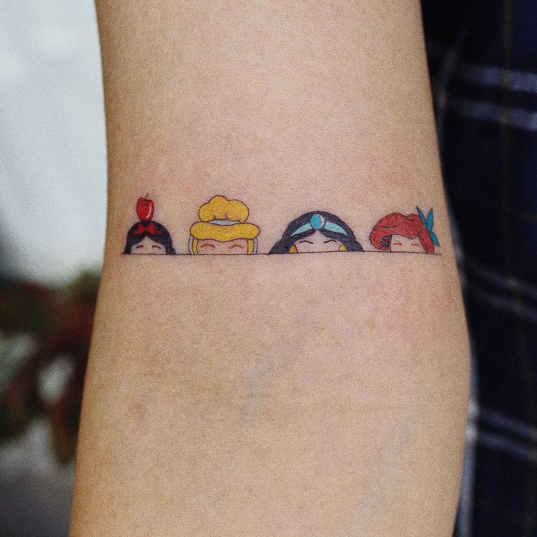 This tattoo features a charming minimalist design of the Disney princesses.
