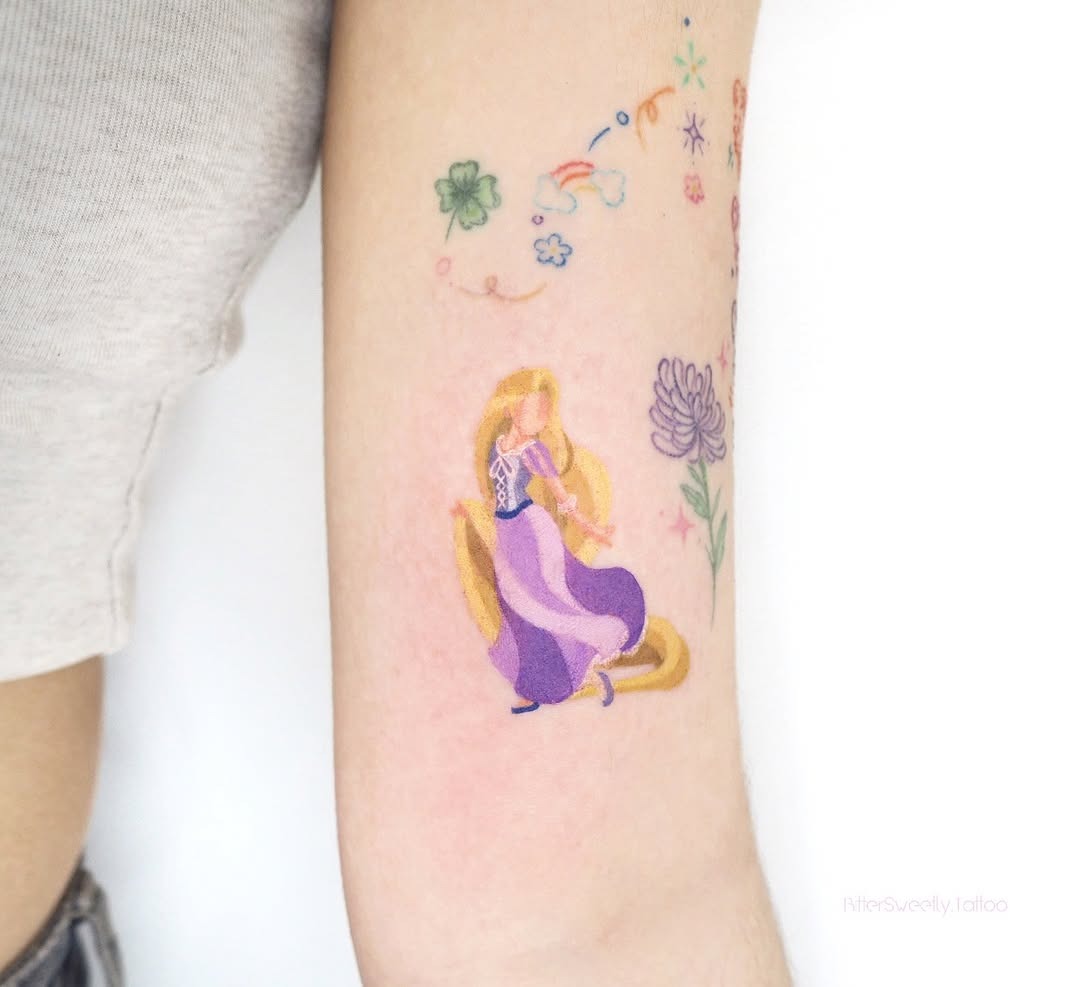 This tattoo features Rapunzel in her iconic dress, surrounded by delicate flowers and swirling vines.