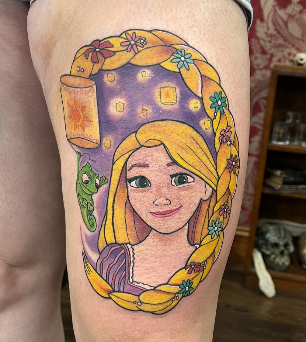 This tattoo features the beloved character Rapunzel, complete with her signature long braid and glowing lanterns.