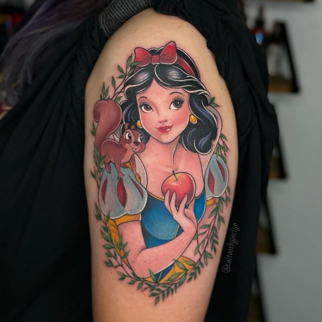 This tattoo features Snow White holding an apple, surrounded by lush greenery.
