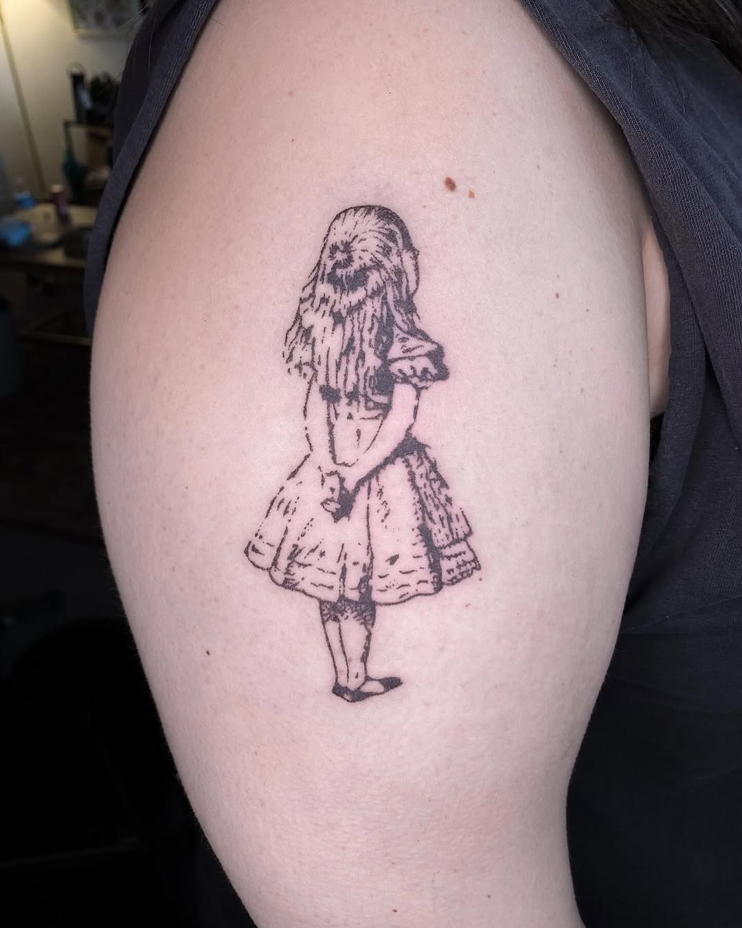 This tattoo showcases a classic portrayal of Alice standing quietly with her hands behind her back.