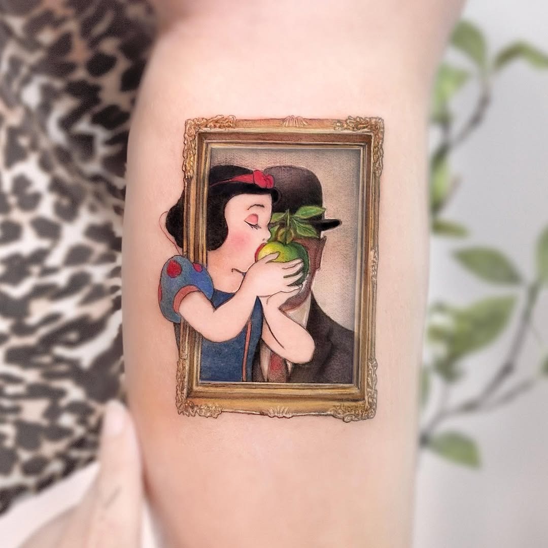 This tattoo beautifully depicts Snow White holding an apple framed in a classic picture frame.