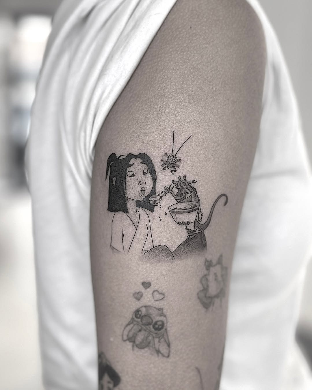 This tattoo features Mulan gently interacting with a cat, showing her playful spirit.