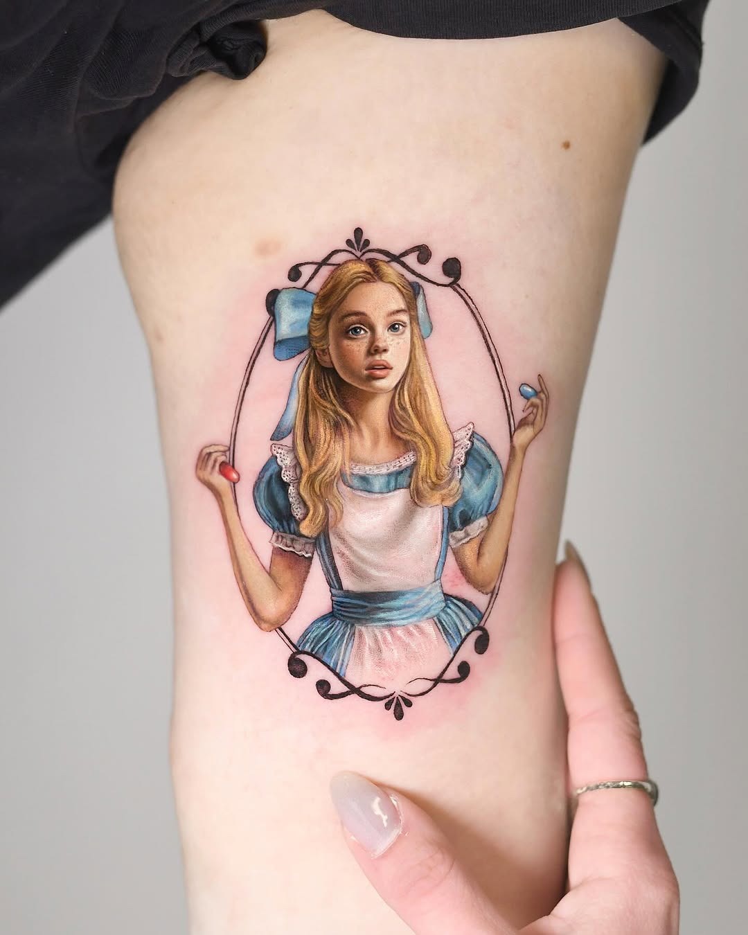 This tattoo captures Alice beautifully, showing intricate details and colors.