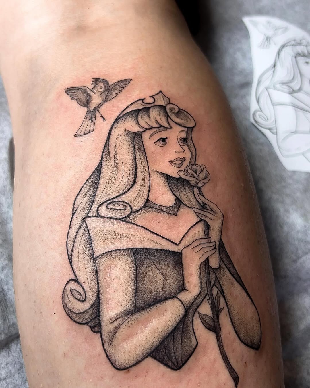 This beautiful tattoo features Aurora from Sleeping Beauty, delicately rendered in a vintage style.